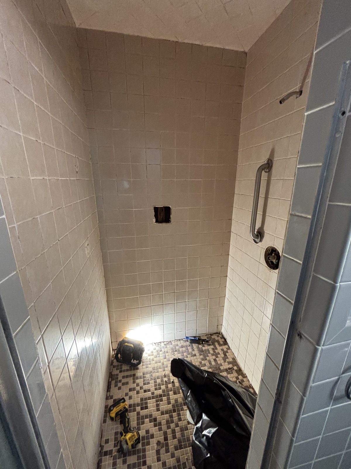Shower fixtures and floor removed during demolition